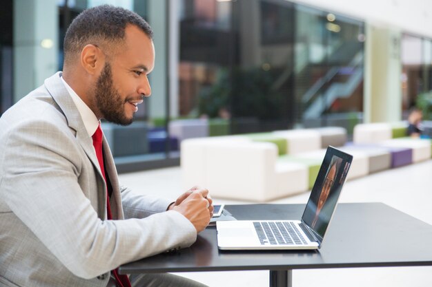 Gai homme d'affaires discutant via un ordinateur portable