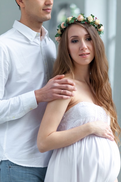 Gai jeune couple vêtu de blanc debout à la maison