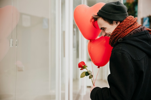 Gai jeune homme avec des ballons dans la rue