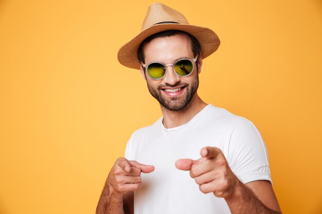 Gai jeune homme debout isolé sur mur orange