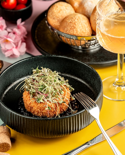Galette de poulet pané croustillant garni d'herbes dans un bol noir