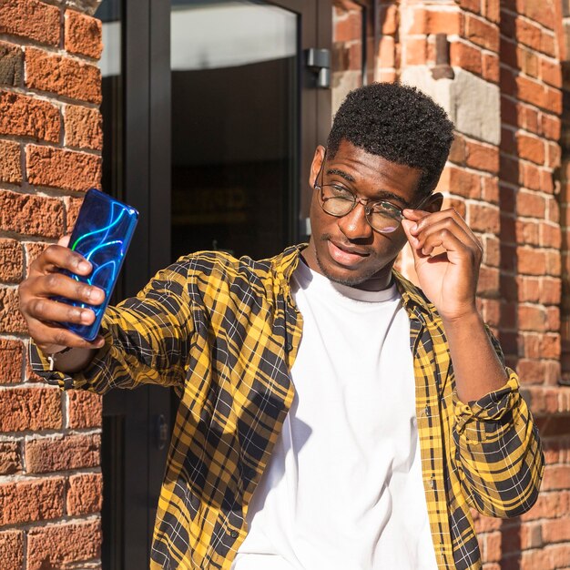 Garçon adolescent coup moyen prenant un selfie