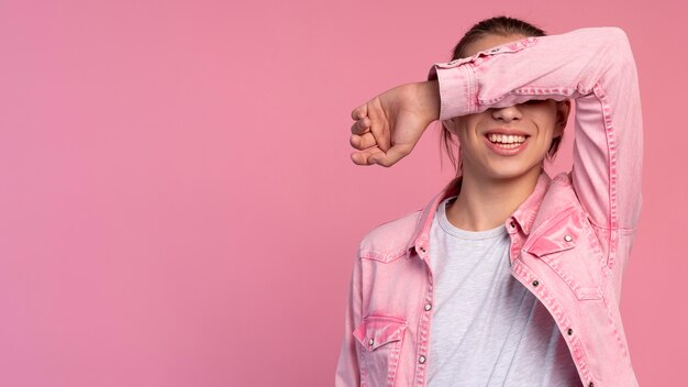 Garçon adolescent élégant en rose posant avec espace de copie