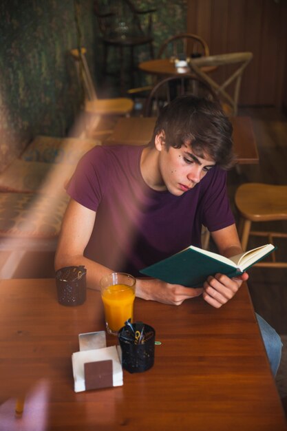 Garçon adolescent, lecture, garçon, dans, joli, café