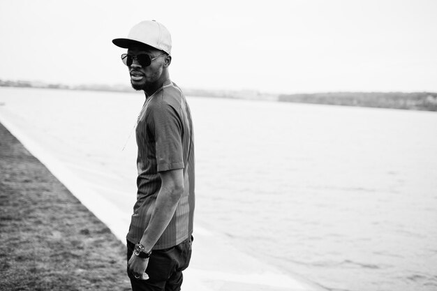 Un garçon afro-américain élégant porte un t-shirt de football et des lunettes de soleil Portrait d'homme de sport noir