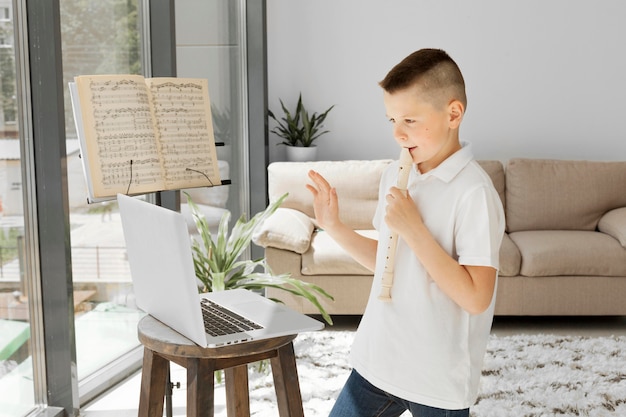 Garçon apprenant des cours en ligne à partir d'un ordinateur portable