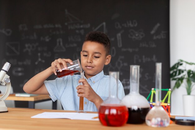 Garçon apprenant plus sur la chimie en classe