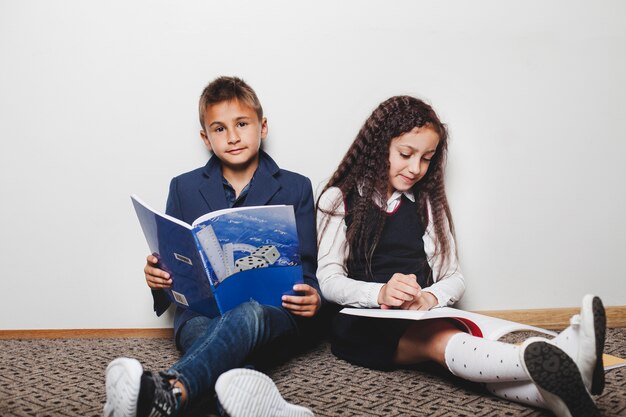 Garçon assis avec un livre de lecture de fille