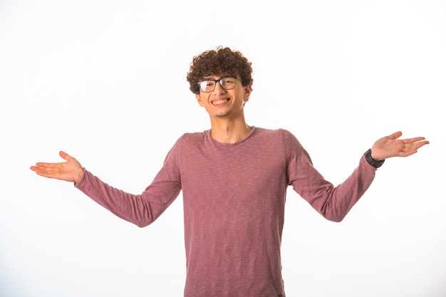 Photo gratuite le garçon aux cheveux bouclés en lunettes optiques a l'air réussi et chanceux.