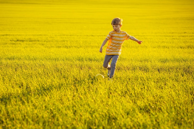 Garçon avec ballon de foot dans le pré