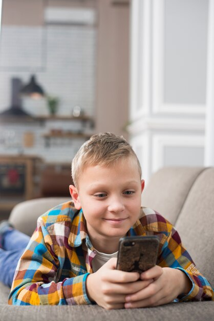 Garçon sur un canapé à l&#39;aide de smartphone