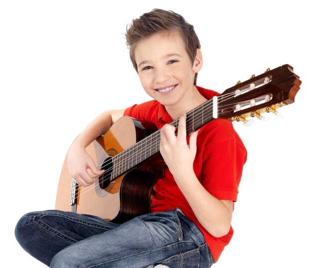 Garçon caucasien souriant joue à la guitare acoustique -