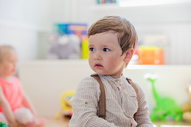 Garçon en chemise rayée en détournant les yeux