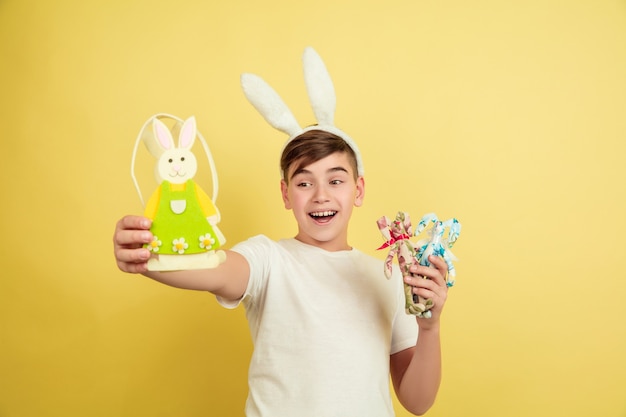 Garçon comme un lapin de Pâques sur le mur jaune du studio