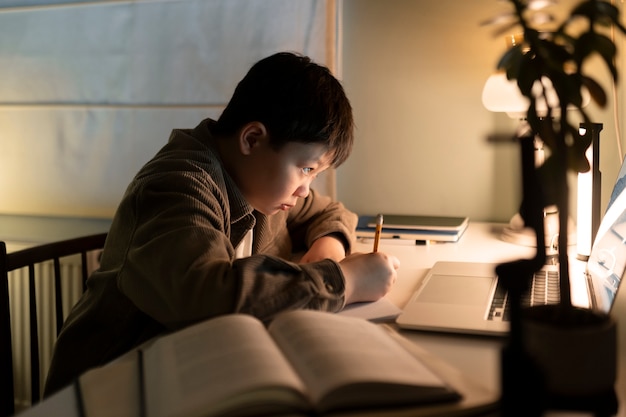 Garçon de coup moyen à faire ses devoirs