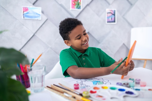 Garçon avec un crayon regardant dans la tablette