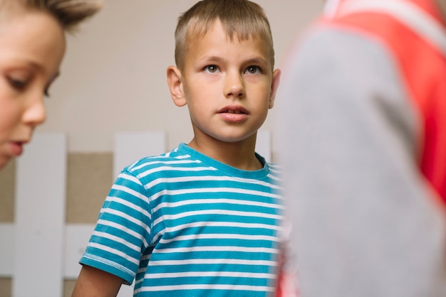 Garçon debout avec ses camarades de classe