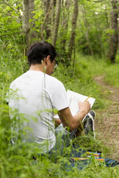 Garçon dessin au fusain dans le bois