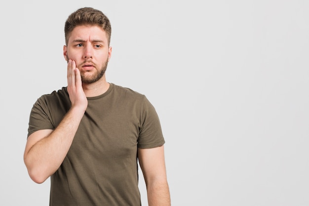 Garçon avec douleur sur la joue