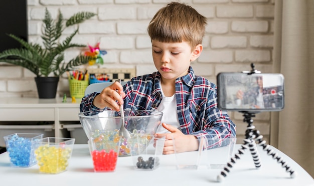 Photo gratuite garçon avec enregistrement de boules d'hydrogel