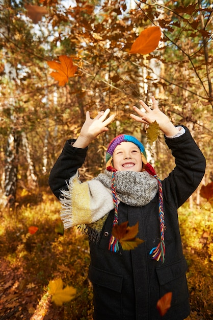 Photo gratuite garçon essayant d'attraper autant de feuilles qu'il peut