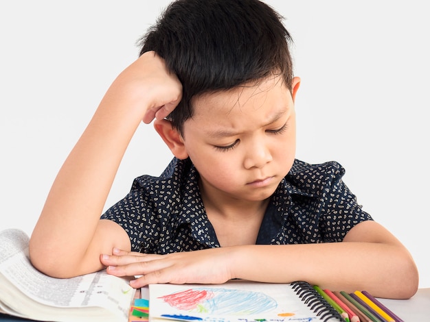 Un garçon est malheureux à faire ses devoirs