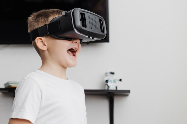 Photo gratuite garçon étant heureux parce qu'il utilise un casque de réalité virtuelle