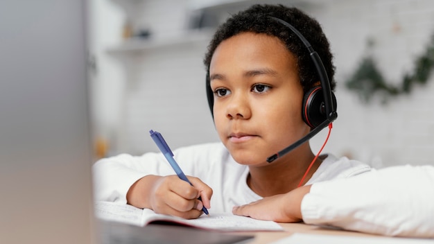 Garçon à faire ses devoirs avec l'utilisation d'un ordinateur portable