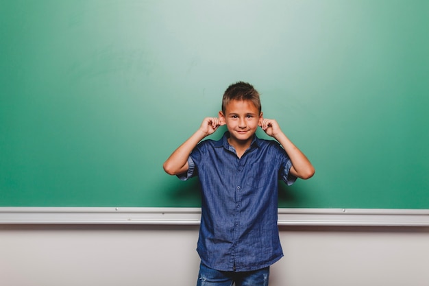 Photo gratuite garçon faisant des visages dans la salle de classe