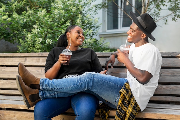 Garçon et fille appréciant des smoothies ensemble