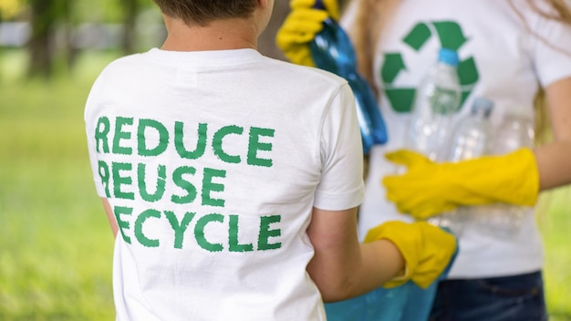 Photo gratuite garçon et fille à la collecte des ordures en plastique dans un parc