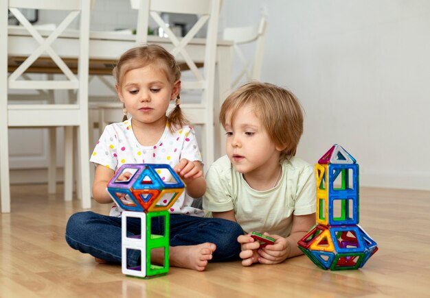 Garçon et fille à la maison jouant avec des jouets