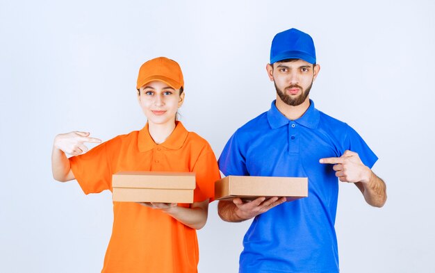 Garçon et fille en uniformes bleus et jaunes tenant plusieurs paquets à emporter.