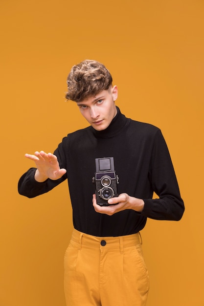 Garçon filme avec un caméscope dans une scène jaune