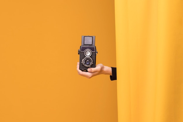 Photo gratuite garçon filme avec un caméscope dans une scène jaune