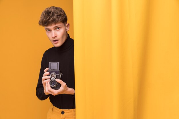 Garçon filme avec un caméscope dans une scène jaune
