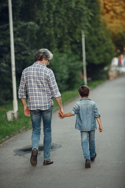 Garçon et grand-père marchent dans le parc. Vieil homme jouant avec son petit-fils.