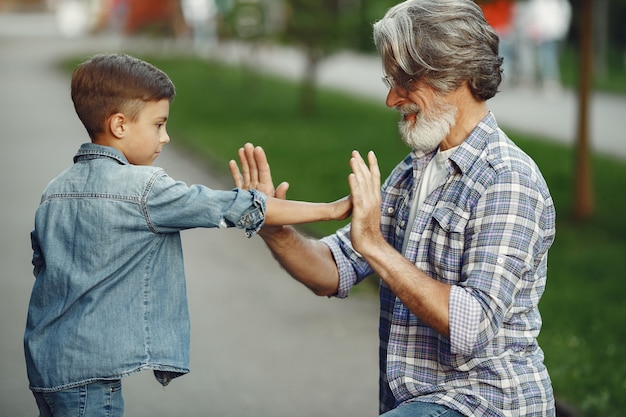 Garçon et grand-père marchent dans le parc. Vieil homme jouant avec son petit-fils.