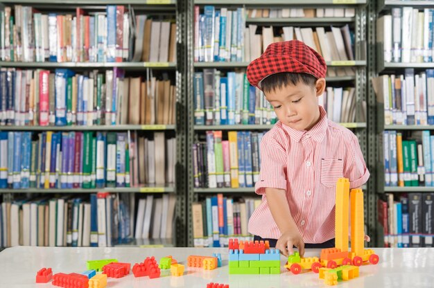 Garçon jouant avec des blocs de plastique dans l&#39;école de la bibliothèque
