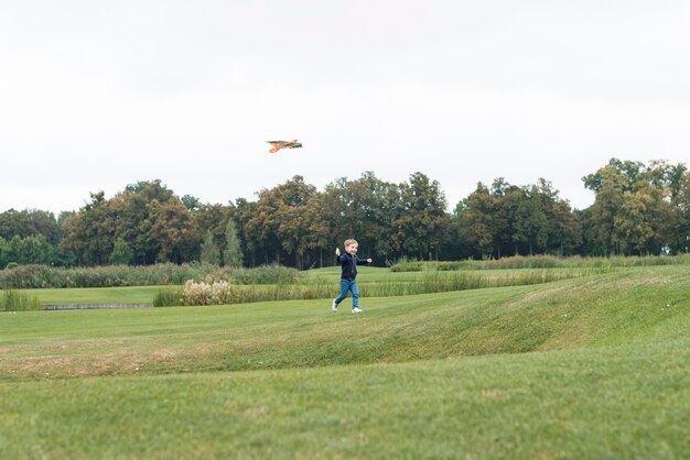 Garçon jouant avec un cerf-volant long shot