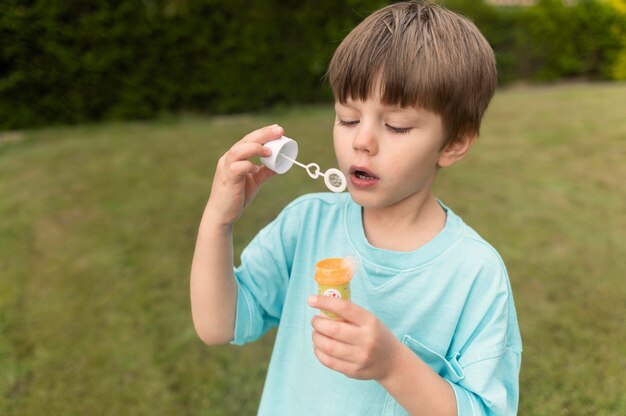 Garçon jouant avec du savon à bulles