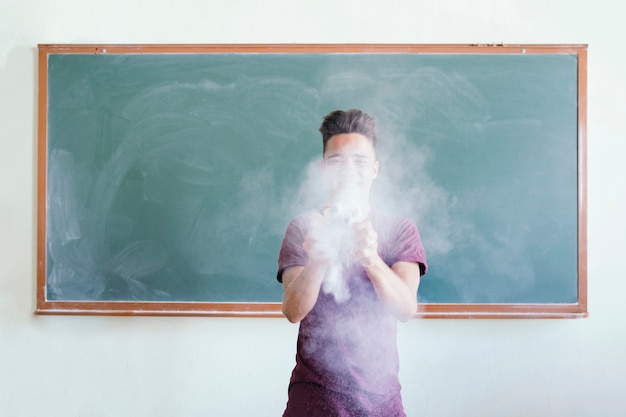 Photo gratuite garçon jouant avec des gommes et des poussières de craie