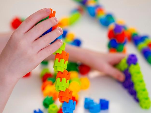 Photo gratuite garçon jouant avec un jeu de tour coloré