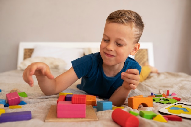 Photo gratuite garçon jouant avec des jouets de casse-tête