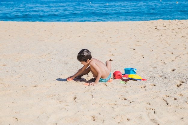 Garçon jouant de jouets sur th esand