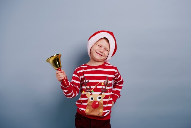 Garçon joyeux avec cloche au studio shot