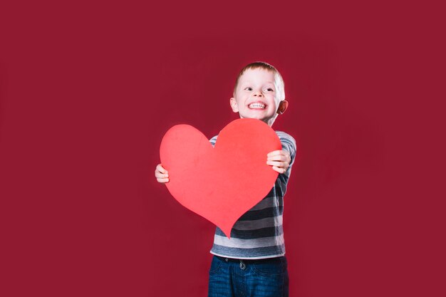 Garçon joyeux donnant le coeur