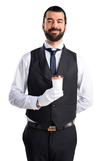 Un garçon de luxe tenant une tasse de café