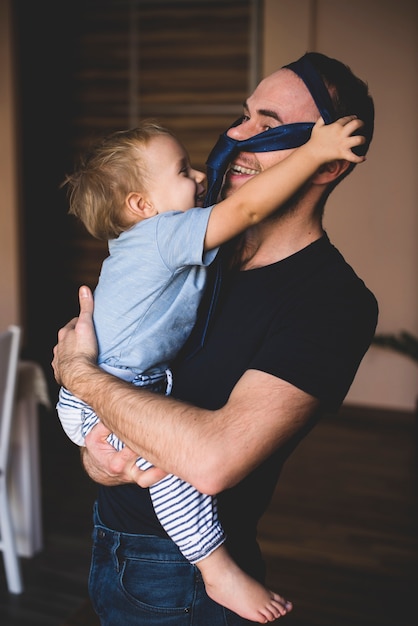 Photo gratuite garçon mettant une cravate sur la tête de son père