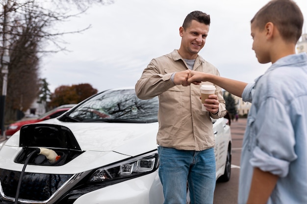 Garçon et papa près d'une voiture électrique